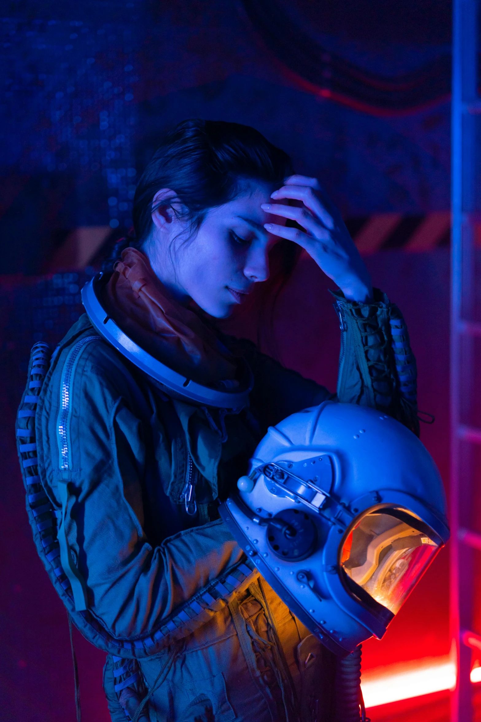 a woman in a space suit holding a helmet, by Adam Marczyński, vibrant cinematic lighting, looking sad, wearing flight suit, promotional image