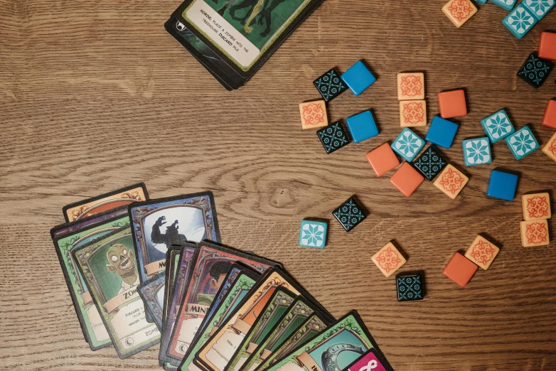 a bunch of cards sitting on top of a wooden table, a screenshot, cubes on table, fighting fantasy, detailed product photo, flattened
