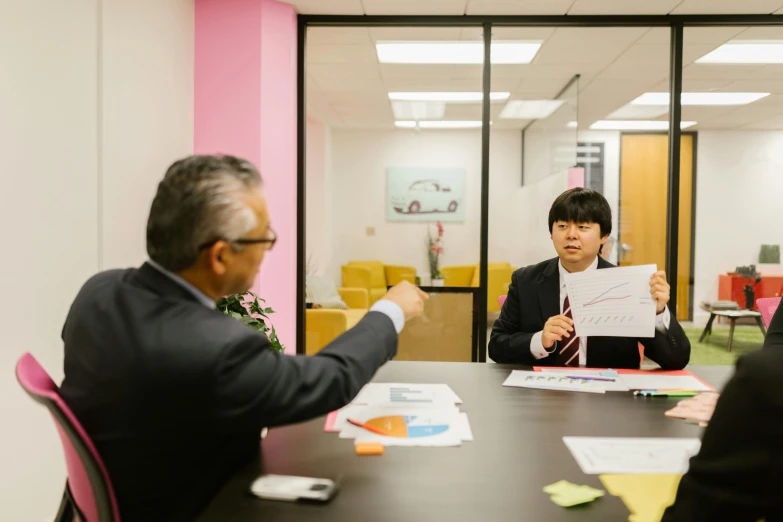 a group of people sitting around a table, in an office, darren quach, frank frazzeta