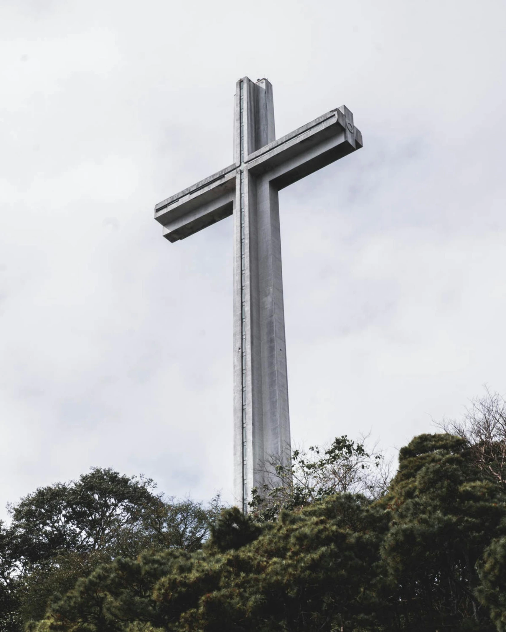 a large metal cross on top of a hill, a statue, inspired by Kōno Michisei, unsplash, hurufiyya, snapchat photo, lgbt, made of cement, taiwan