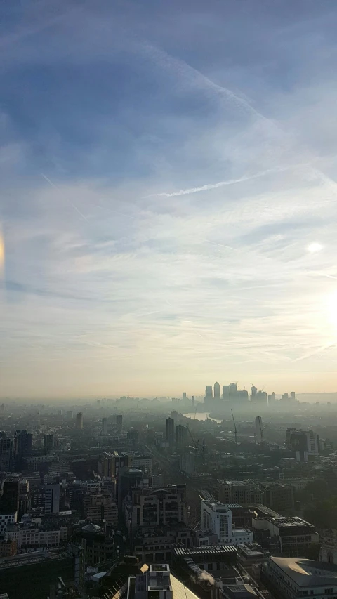 a view of a city from the top of a building, inspired by Richard Wilson, hazy sun and mystical, lens flares, london, midday photograph