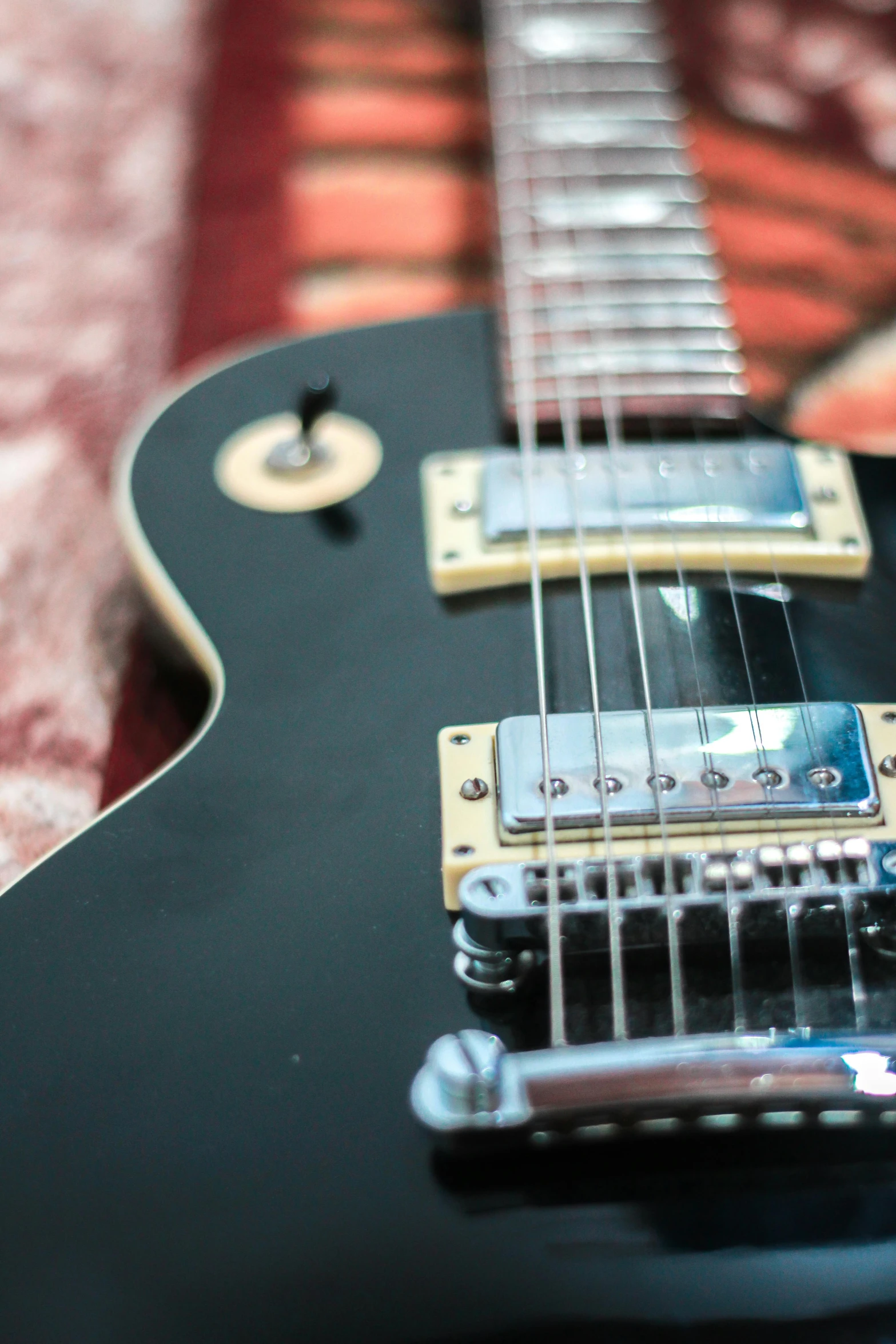 a black electric guitar sitting on top of a bed, pexels contest winner, profile image, rectangle, with lots of details, electronics