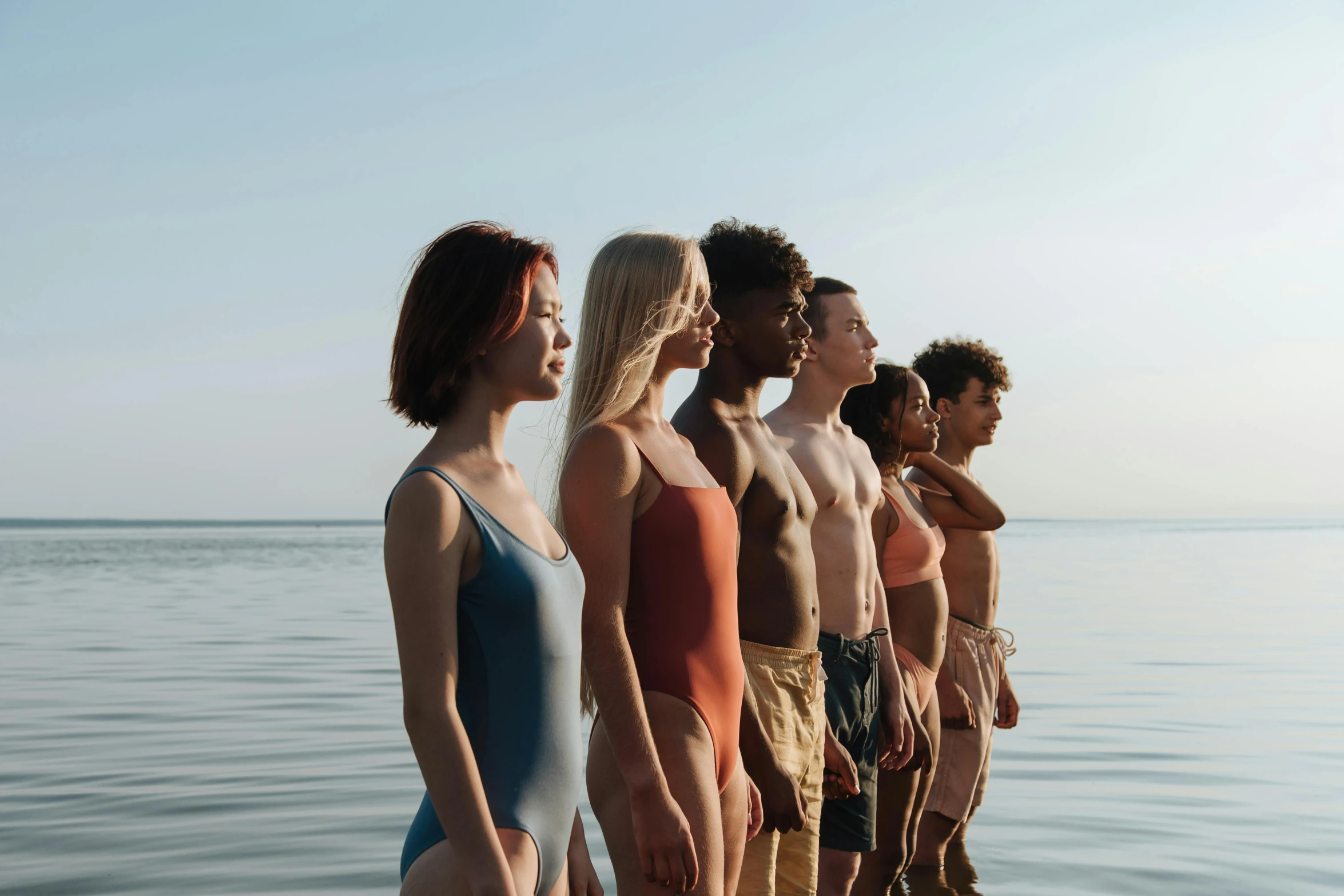 a group of people standing on top of a body of water, by Carey Morris, antipodeans, warm skin tone, profile image, cute girl wearing tank suit, varying ethnicities