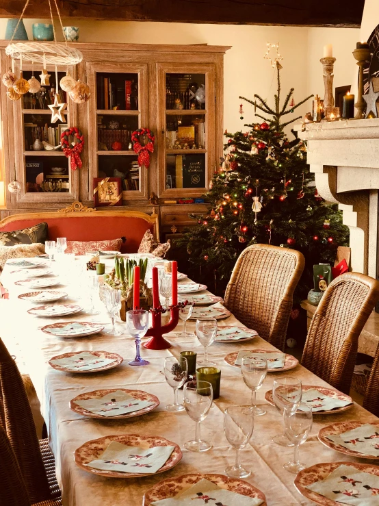 a dining room table with a christmas tree in the background, renaissance, traditional corsican, cosy, long table, profile image