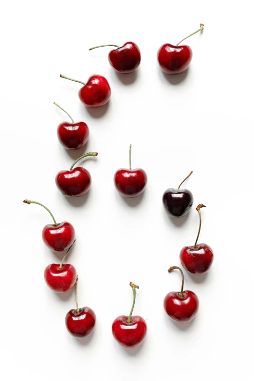 a number of cherries arranged in a circle, letter s, profile image, ben mauro, studio product shot