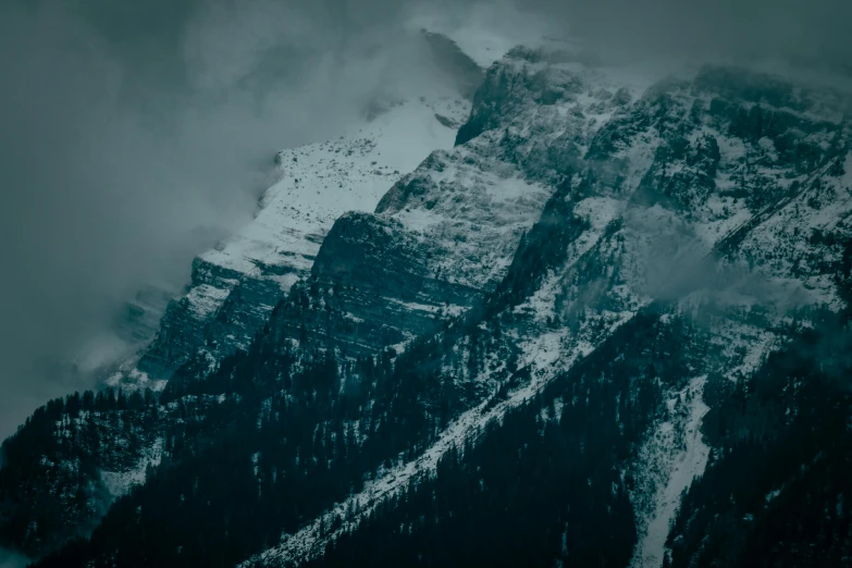 a mountain covered in snow under a cloudy sky, inspired by Elsa Bleda, pexels contest winner, baroque, ominous dark background, banff national park, high cliff, grey