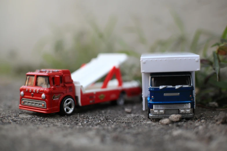 two toy trucks are parked next to each other, pexels contest winner, very tiny, tony taka, rectangle, opening shot