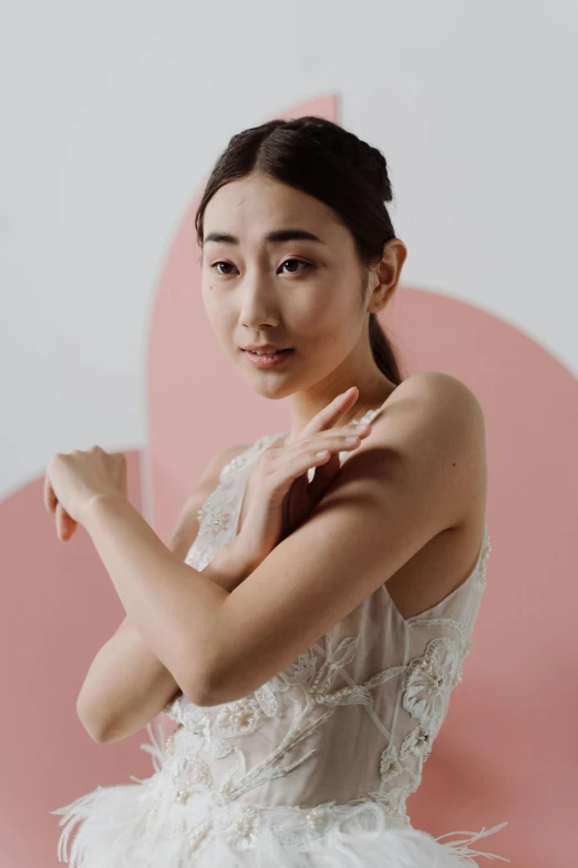 a woman in a white dress posing for a picture, inspired by Zhou Wenjing, trending on pexels, visual art, with index finger, ethnicity : japanese, translucent skin, blushing