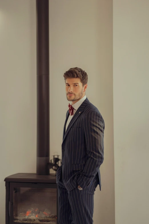 a man in a suit standing in front of a stove, inspired by Ramon Pichot, instagram, pinstripe suit, male model, soccer player timo werner, blair armitage
