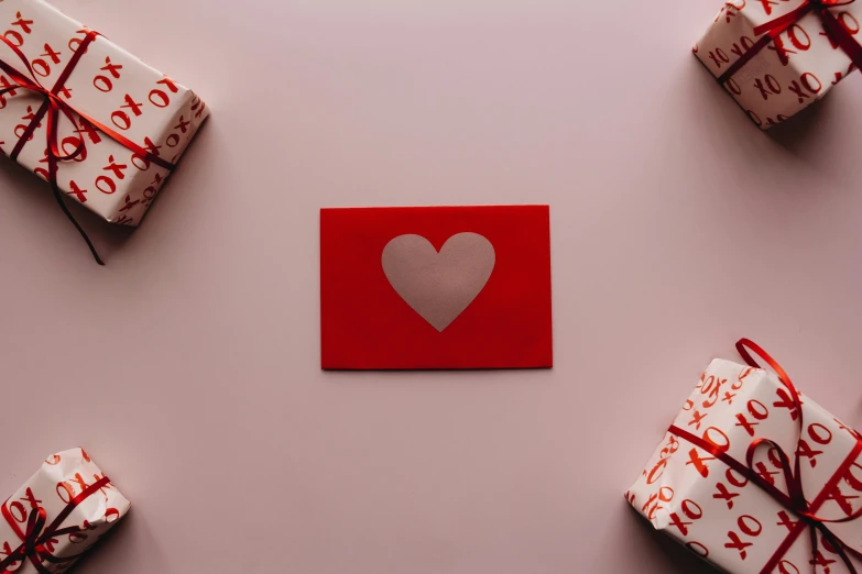 a red envelope with a heart cut out of it surrounded by wrapped presents, by Julia Pishtar, flat lay, profile image, silver red, thumbnail