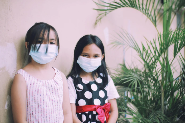 a couple of little girls standing next to each other, pexels contest winner, medical mask, avatar image, hospital, environmental