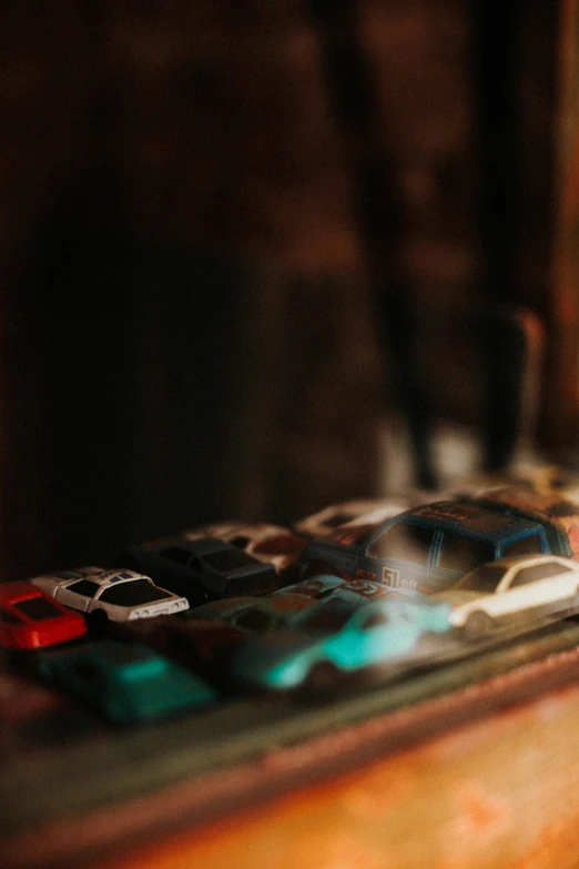 a remote control sitting on top of a wooden table, a tilt shift photo, inspired by Elsa Bleda, unsplash, photorealism, rusty cars!!, display case, multicoloured, translucent