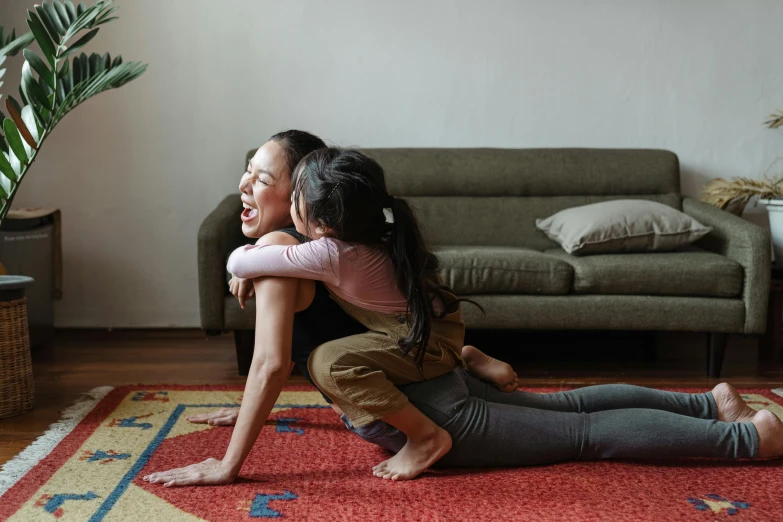 a couple of young girls sitting on top of a rug, pexels contest winner, stretch, an asian woman, smiling playfully, daughter