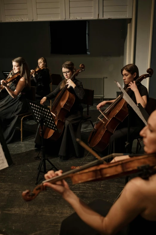 a group of people playing musical instruments in a room, masked female violinists, dark. no text, sheet music, college