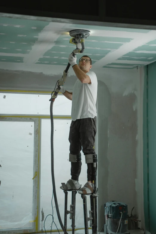 a man is painting the ceiling of a room, full body 8k, covered in dust, with cables and wires coming out, promo image