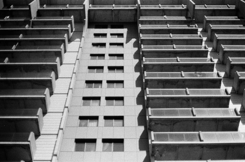 a black and white photo of a tall building, a black and white photo, inspired by André Kertész, unsplash, brutalism, cinder blocks, photo taken on fujifilm superia, square lines, soviet apartment