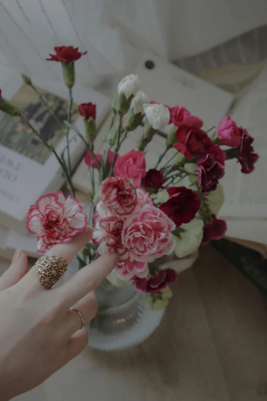 a close up of a person holding a bouquet of flowers, sitting with flowers, multiple stories, carnation, rings