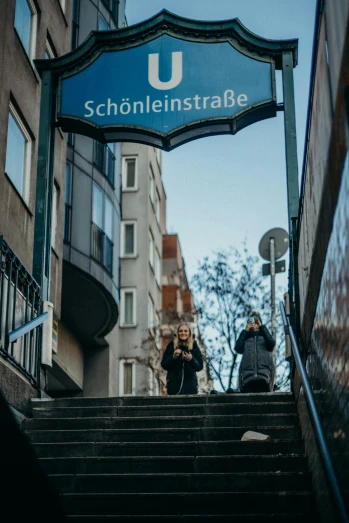 a couple of people that are walking up some stairs, unsplash, berlin secession, signboards, schools, underground scene, low quality photo