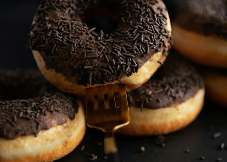 a pile of donuts with chocolate frosting and sprinkles, a portrait, by Daniel Seghers, trending on pexels, hurufiyya, dark brown, slim, bronze, 1 4 9 3