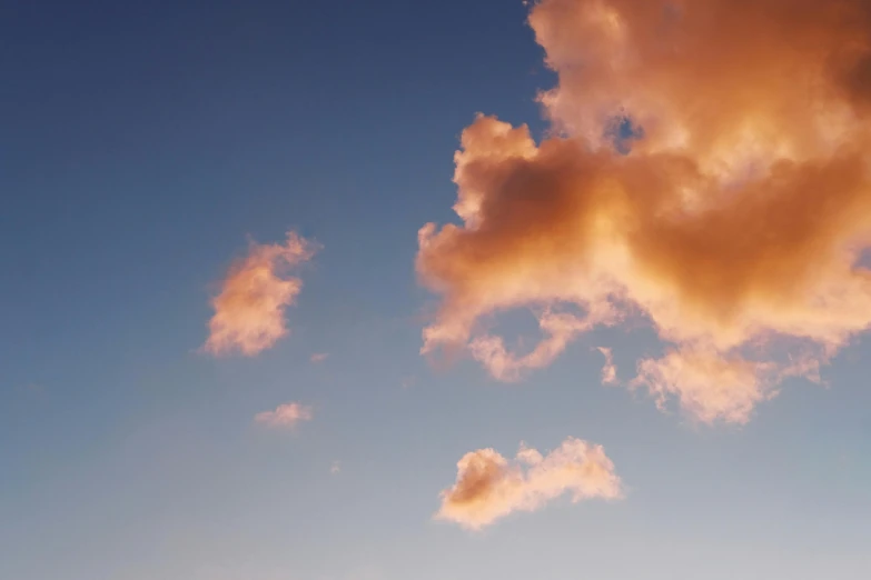 a man flying a kite on top of a lush green field, unsplash, aestheticism, light pink clouds, layered stratocumulus clouds, pastel orange sunset, colour photograph