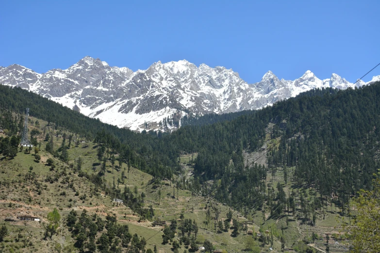 a view of a mountain range with trees in the foreground, by Muggur, pexels contest winner, hurufiyya, clear blue skies, 3/4 front view, three fourths view, white