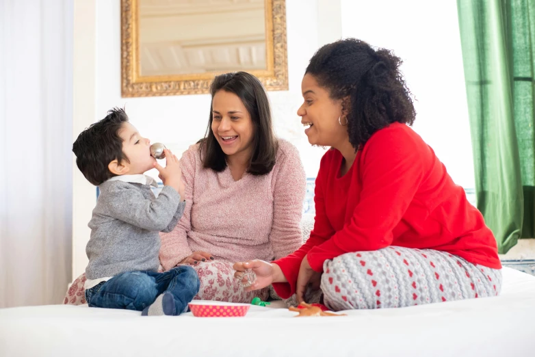 a woman and two children sitting on a bed, pexels contest winner, happening, festive, mutahar laughing, hispanic, profile image