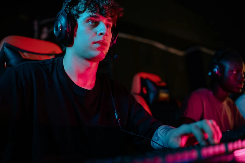 a man sitting in front of a keyboard with headphones on, tournament, 15081959 21121991 01012000 4k, epic game portrait, focused shot