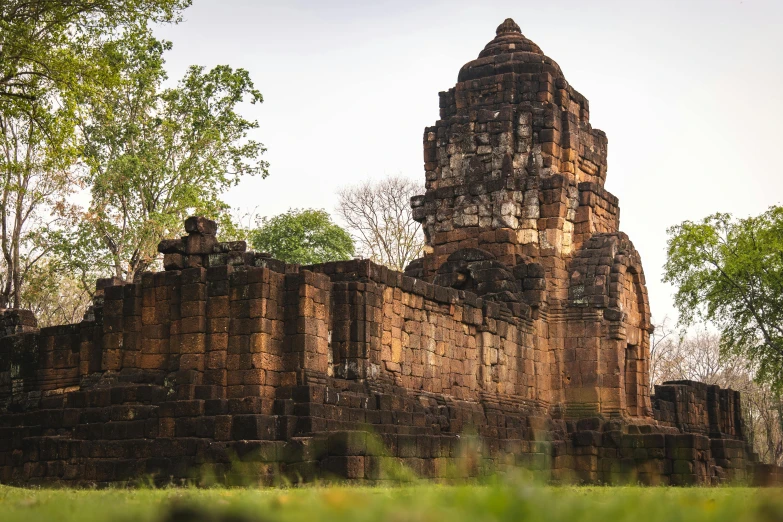 a large stone building sitting on top of a lush green field, sukhothai costume, thumbnail, winter sun, fan favorite