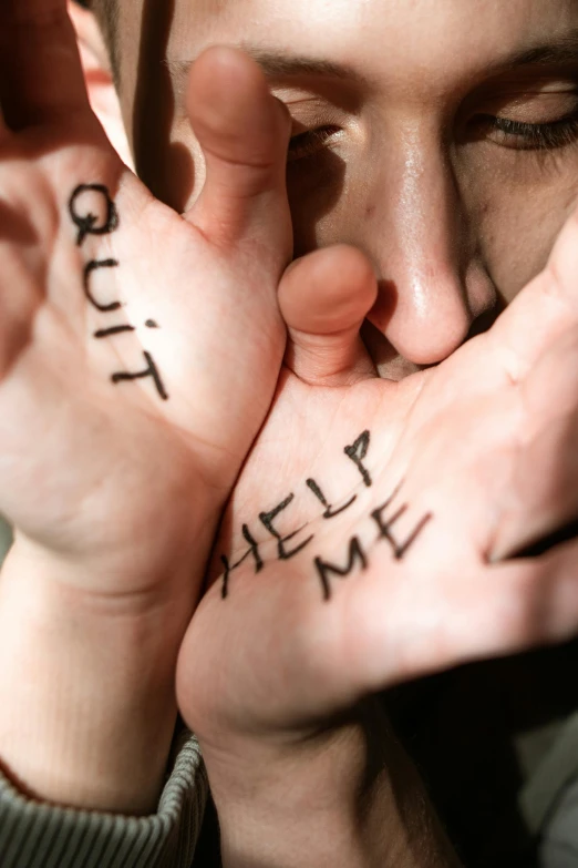 a woman covering her face with her hands, trending on pexels, words, sitting on man's fingertip, scars, help me