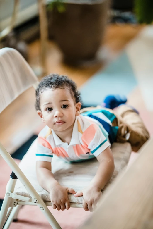 a little boy that is laying down on a chair, by Washington Allston, walking towards the camera, diverse, caring fatherly wide forehead, promo image