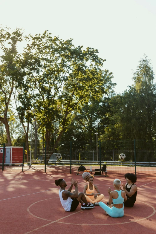 a group of people sitting on top of a tennis court, berlin park, golden hour 8 k, playing soccer, well shaded