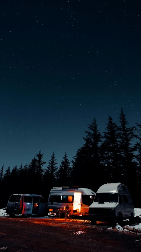 a couple of trucks that are parked in the snow, by Filip Hodas, minimalism, in the forest at night, pacific northwest, square, low quality photo