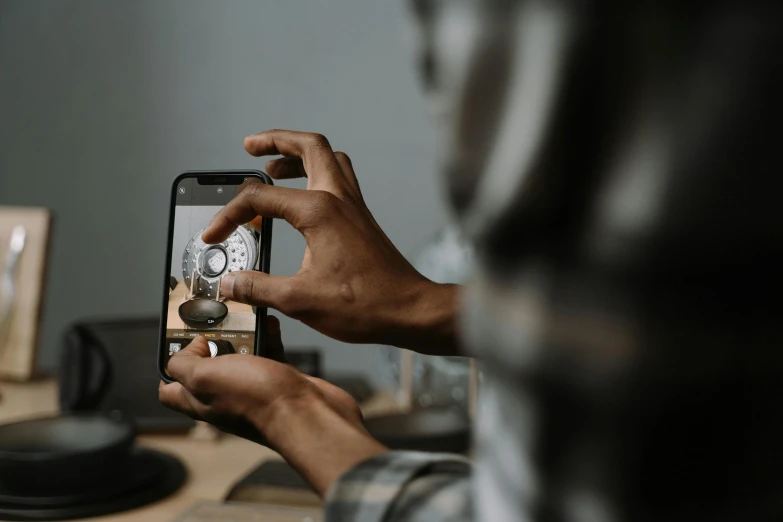 a person taking a picture of a clock on a cell phone, trending on pexels, man is with black skin, brown, rule of thirds, inspect in inventory image