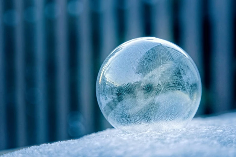 a glass ball sitting on top of a snow covered ground, icicle, soap bubble