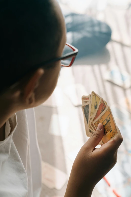 a woman holding a bunch of money in her hand, pexels contest winner, visual art, playing board games, the front of a trading card, looking outside, childhood