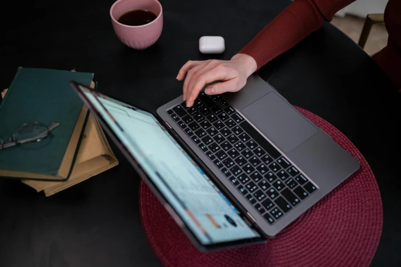 a woman sitting at a table using a laptop computer, by Carey Morris, pexels, bottom angle, maintenance, rectangle, covered