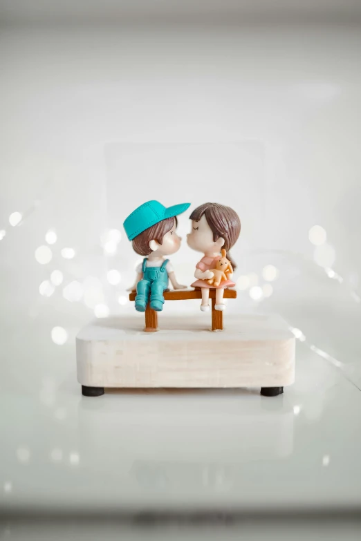 a couple of figurines sitting on a bench, light frame, k-pop, kissing each other, stop motion vinyl figure