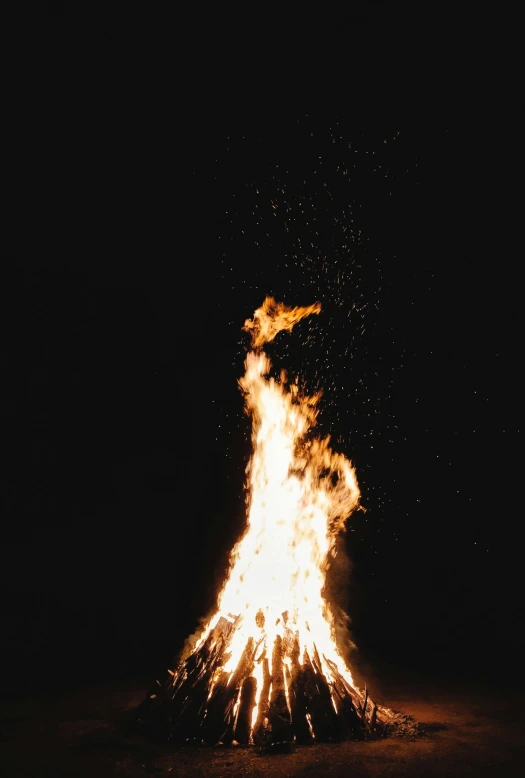 a bonfire is lit up in the dark, an album cover, unsplash, tall, grainy, 🚀🚀🚀, high quality photo