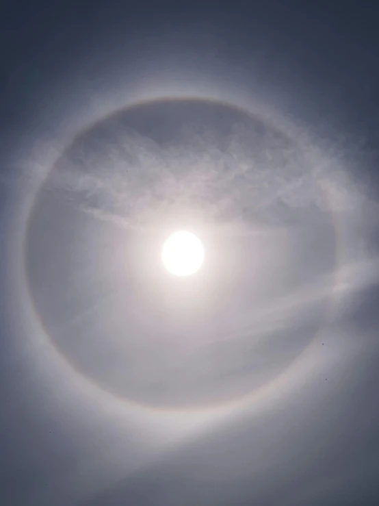 the sun is shining brightly through the clouds, a hologram, inspired by Gabriel Dawe, pexels contest winner, romanticism, circular white full moon, prismatic halo, instagram post, enso