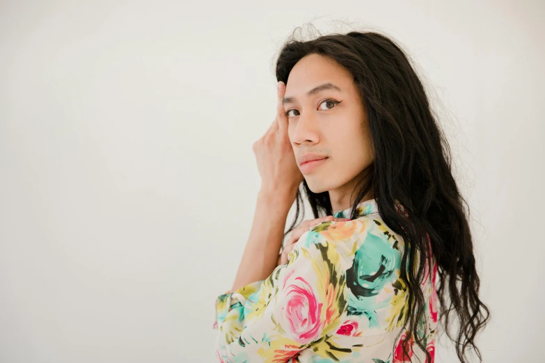 a woman holding a cell phone to her ear, by Olivia Peguero, pexels contest winner, hyperrealism, floral clothes, bedhead, mixed race woman, in front of white back drop