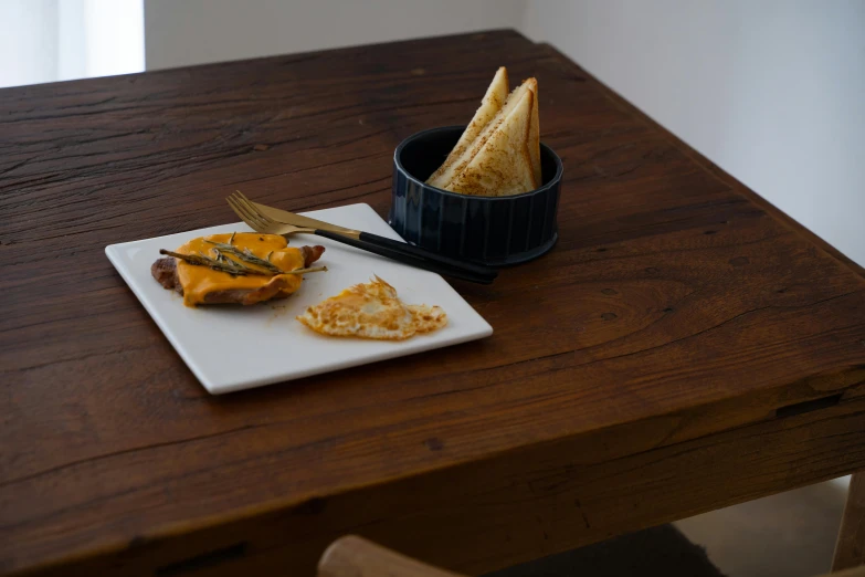 a close up of a plate of food on a table, toast, on a wooden desk, cheddar, profile image