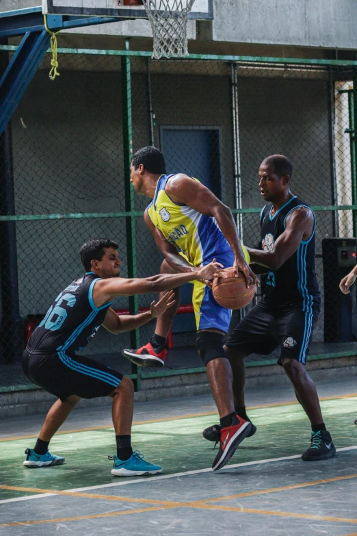 a group of young men playing a game of basketball, zoomed in shots, in sao paulo, intense colours, defence