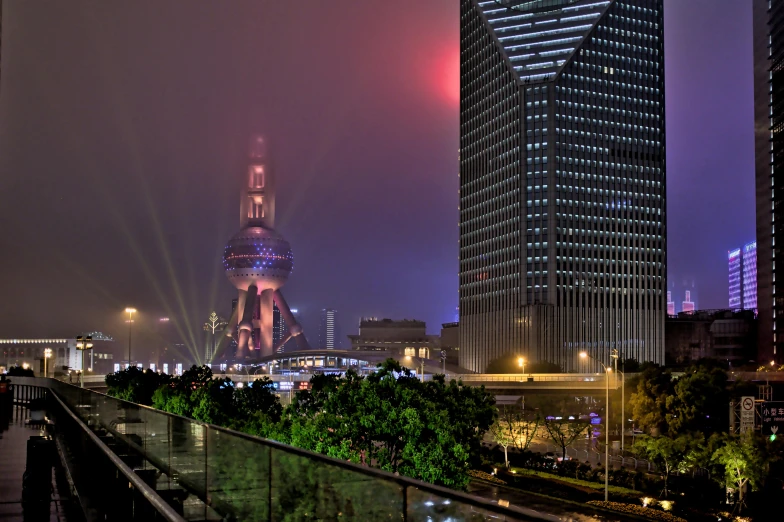 a view of a city at night with the eiffel tower in the background, inspired by Cheng Jiasui, pexels contest winner, realism, foggy neon night, shanghai city, architecture photo, 2022 photograph