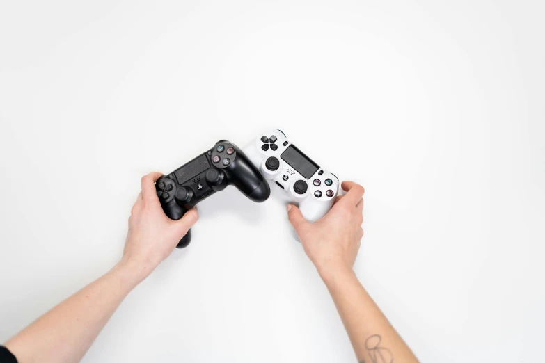 a person holding a video game controller in their hands, by Carey Morris, unsplash, on a white table, dueling, first playstation graphics, black on white