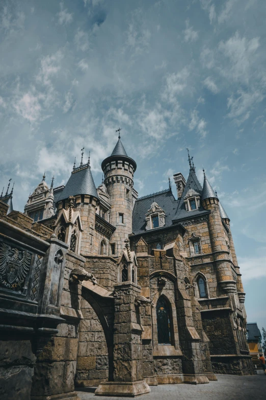 a large castle sitting on top of a lush green field, a photo, by Jacob Toorenvliet, pexels contest winner, renaissance, gothic building style, amusement park buildings, blue, howl's moving castle