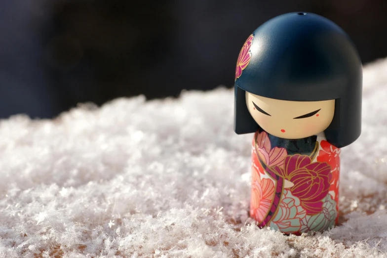 a close up of a doll in the snow, inspired by Nara Yoshitomo, unsplash, ukiyo-e, vinyl designer toy, multicoloured, zen garden, wooden