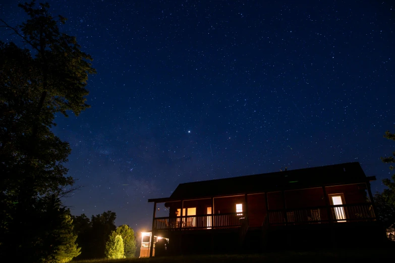 a cabin lit up at night with stars in the sky, light and space, hanging out with orbs, red cloud light, commercial photo, fan favorite