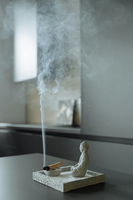 a statue sitting on top of a table with smoke coming out of it, inspired by Kaigetsudō Ando, unsplash, new sculpture, at home, toothpaste refinery, medium close up shot, ignant