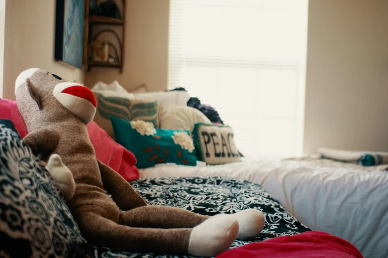 a stuffed animal sitting on top of a bed, unsplash, teenager hangout spot, facing away from camera, college, uncropped