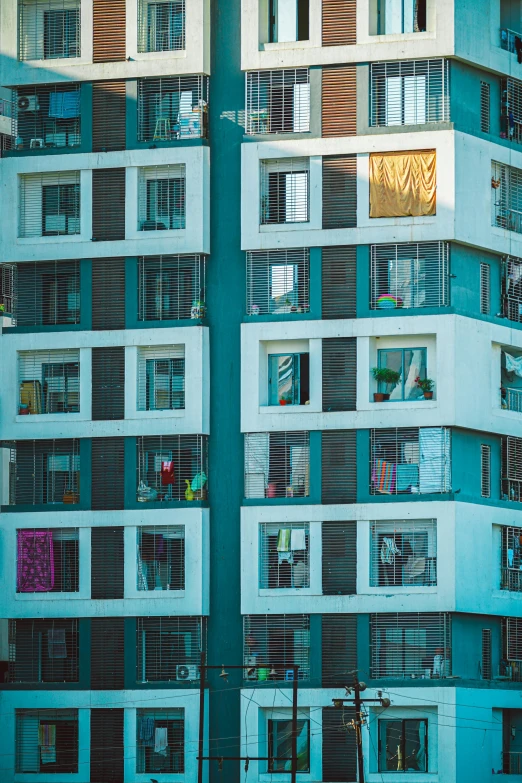 a traffic light in front of a tall building, a photo, inspired by Elsa Bleda, maximalism, laundry hanging, house windows, square, vibrant blue